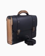 Sac à main Frankie, avec une structure en cuir noir et des panneaux en bois sur les côtés. Il présente des fermetures dorées et une poignée supérieure, accompagné d'une bandoulière assortie.