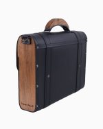 Sac à main Frankie vu de dos et de profil, affichant une finition en cuir noir avec des panneaux en bois. Le design montre des rivets argentés et une poignée en bois, mettant en valeur son style sophistiqué.