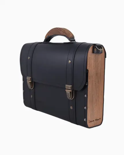 Sac à main Frankie vu de profil, avec une finition en cuir noir et des panneaux en bois sur le côté. Le sac présente des fermetures dorées et une poignée en bois, soulignant son design élégant.