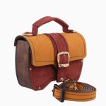 Sac à main Minima avec un design coloré, présentant un rabat en cuir rouge et ocre, et des panneaux en bois sur les côtés. Le sac est équipé d'une boucle dorée et d'une bandoulière assortie.