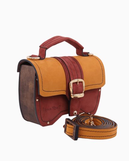 Sac à main Minima avec un design coloré, présentant un rabat en cuir rouge et ocre, et des panneaux en bois sur les côtés. Le sac est équipé d'une boucle dorée et d'une bandoulière assortie.