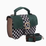 Un sac à main Minima en forme de boîte, avec un design à carreaux noir et blanc sur le devant et un revêtement en suède vert. Le sac présente une poignée supérieure et une bandoulière assortie.