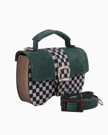 Un sac à main Minima en forme de boîte, avec un design à carreaux noir et blanc sur le devant et un revêtement en suède vert. Le sac présente une poignée supérieure et une bandoulière assortie.