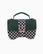 Sac à main Minima vu de face, avec un design à carreaux noir et blanc et un rabat en suède vert. La sacoche est ornée d'une boucle dorée au centre et d'une poignée supérieure.