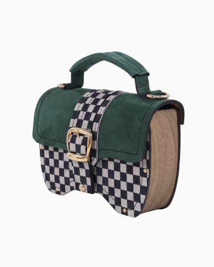 Sac à main Minima vu de profil, avec un design à carreaux noir et blanc et un revêtement en suède vert. La silhouette est légèrement arrondie, mettant en valeur la texture du matériau et la boucle dorée.