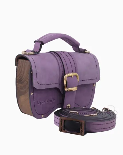 Sac à main Minima en couleur lilas, avec un design élégant en cuir doux et des finitions en bois. Le sac présente une boucle dorée et est accompagné d'une bandoulière assortie.