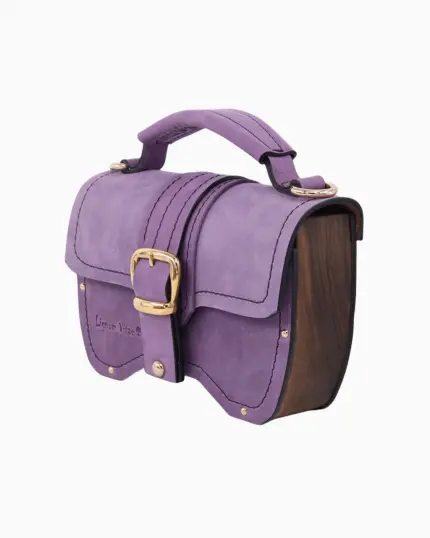 Sac à main Minima en couleur lilas, avec un design élégant en cuir doux et des finitions en bois. Le sac présente une boucle dorée et est accompagné d'une bandoulière assortie.