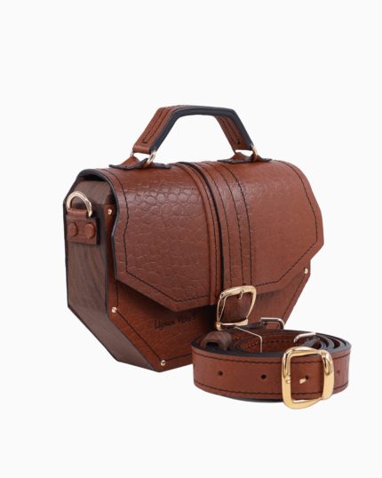 Sac à main Okta, avec un design élégant en cuir texturé marron, mettant en valeur des finitions en bois. Le sac est équipé d'une boucle dorée et d'une bandoulière assortie